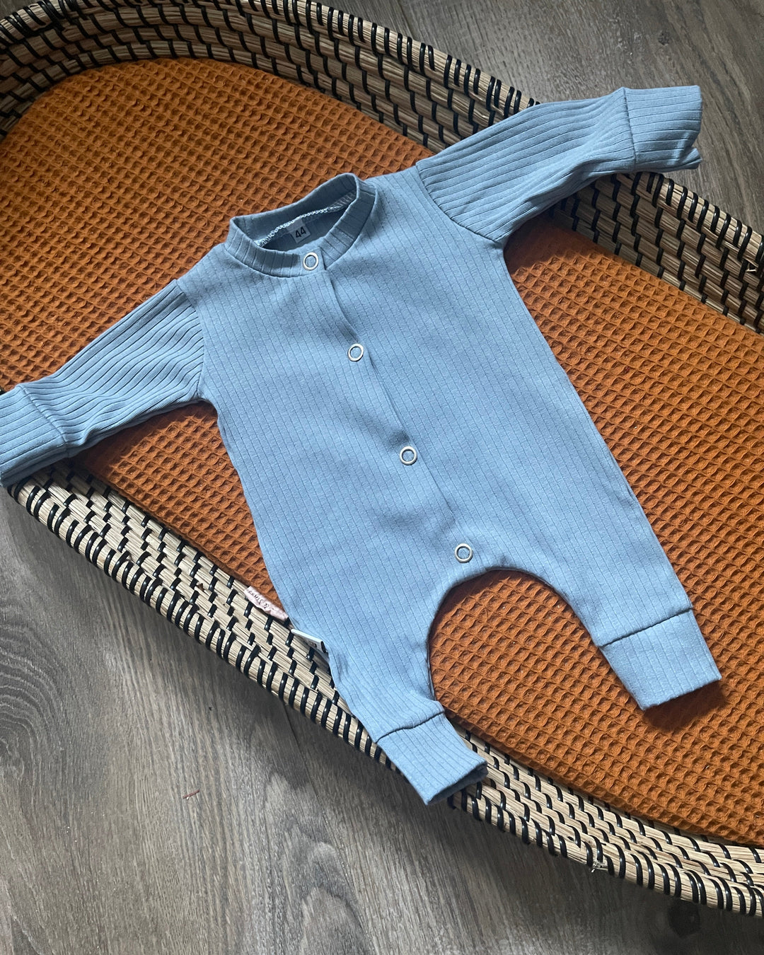 Baby boxpakje in blauwe ribstof, met lange mouwen en drukknoopsluiting