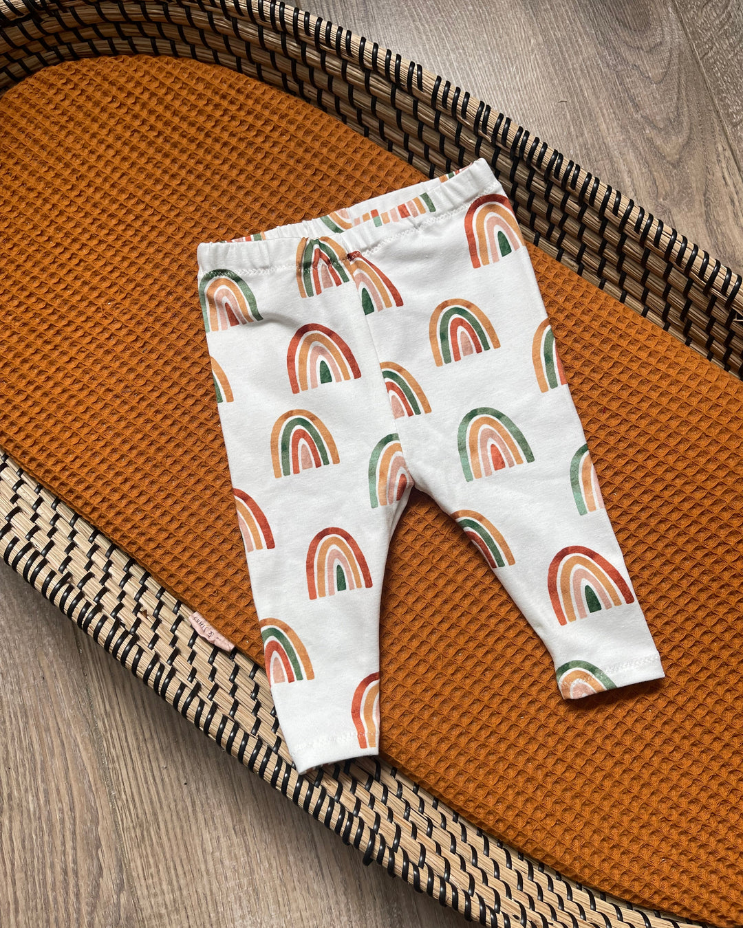 Wit kinderbroekje met rode, oranje en groene regenboog
