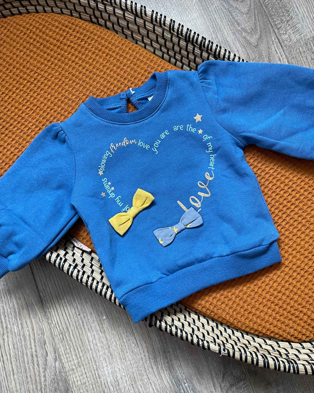 Meisjes blauwe trui met pofmouwen een hart, gele en paarse strikjes