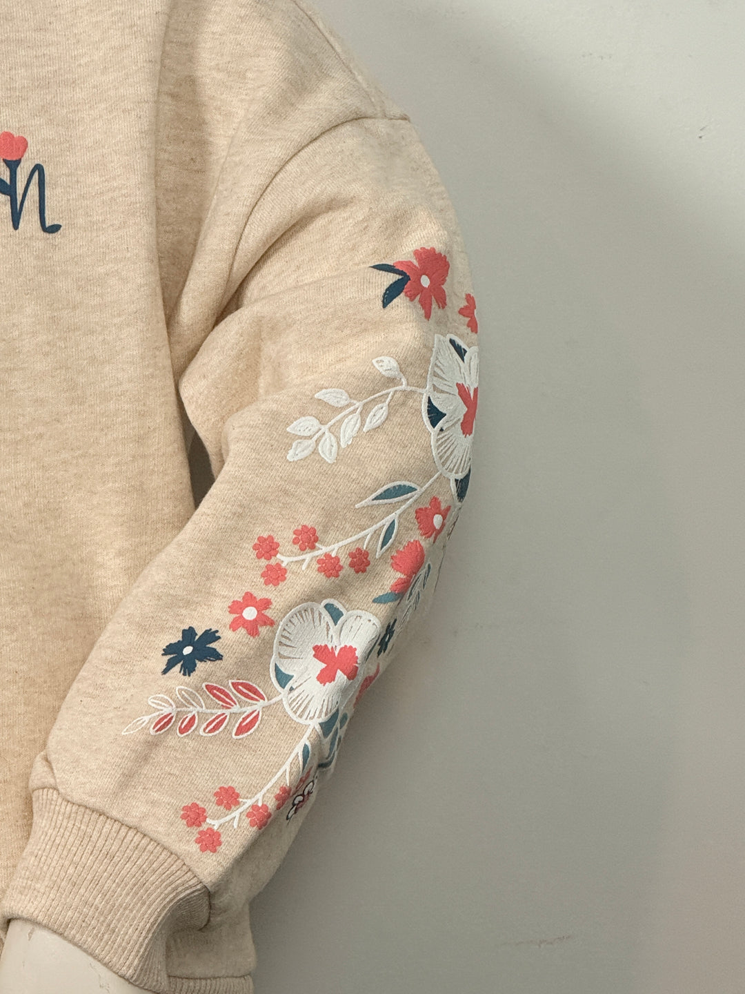 Beige trui met gekleurde bloemen print op mouwen