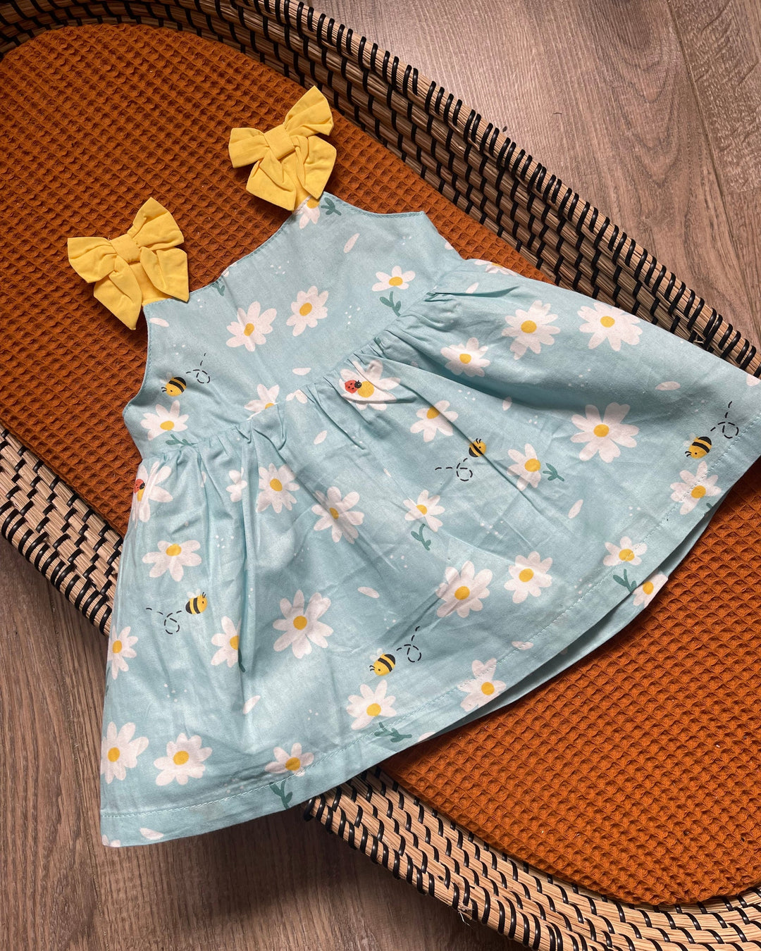 Blauwe baby meisjes jurk met gele strikjes en witte madelief bloemen