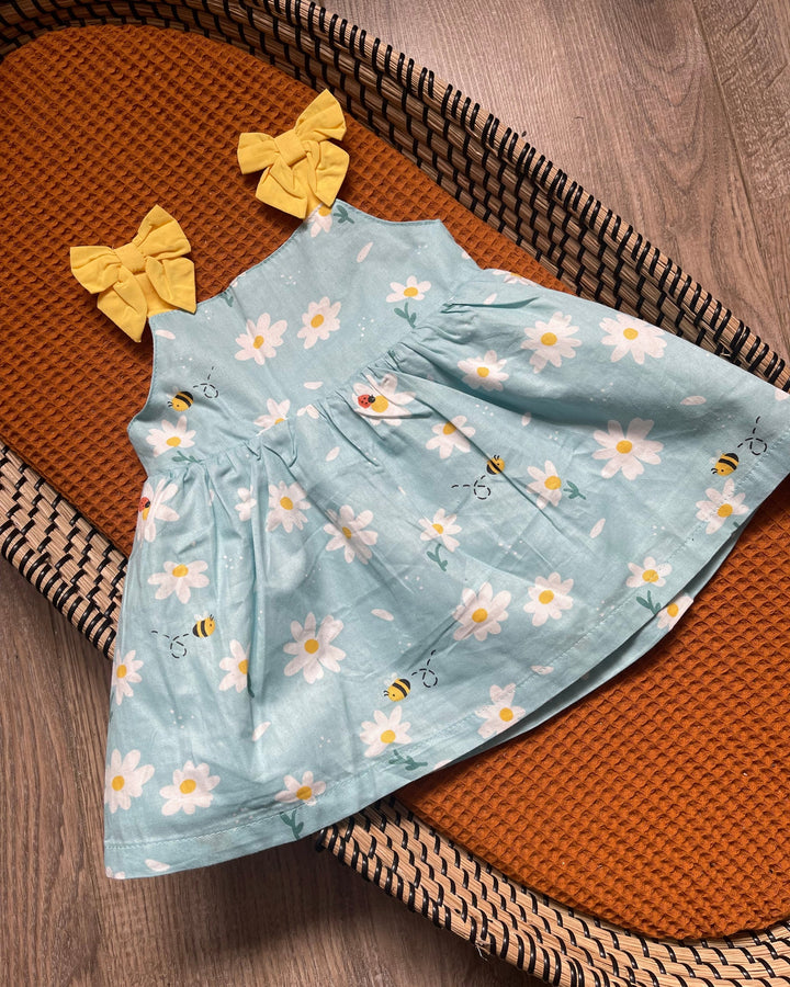 Blauwe baby meisjes jurk met gele strikjes en witte madelief bloemen